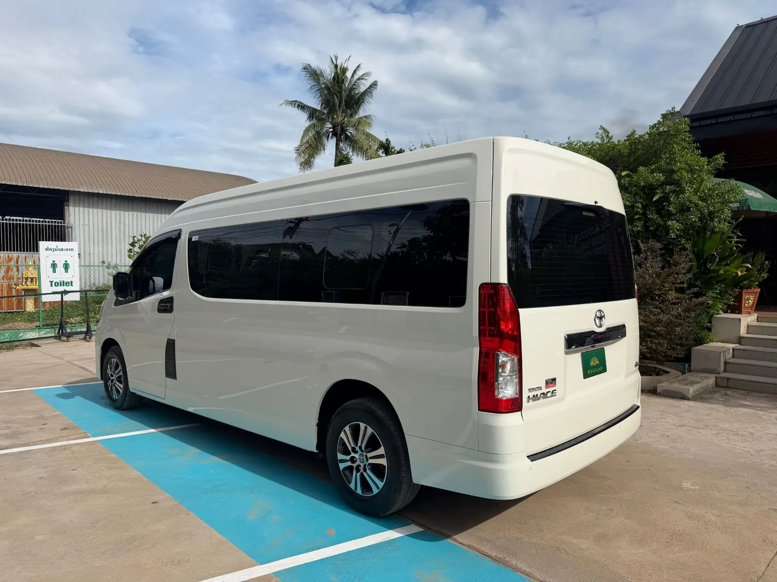 รถตู้ Toyota Hiace ของทีม HUGLAO มุมด้านท้าย เห็นความยาวตัวรถและหลังคาสูง